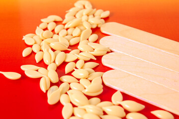wooden spatulas and wax granule for hot wax depilation.
beauty industry background. body care