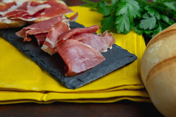 Aperitivo de jamón serrano junto a un pan redondo