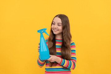 Happy kid hold disinfectant spraying bottle for copy space yellow background, spray