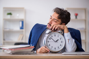 Young male employee in time management concept
