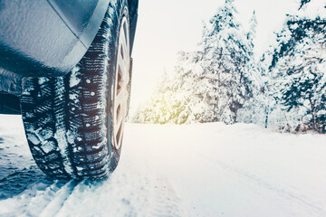 studded car tire on a winter snow-covered road in the forest, winter journey