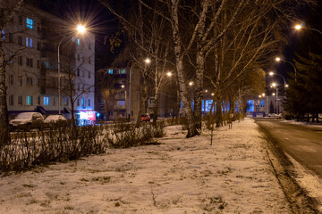Small night city in winter, roads and lanterns.