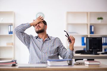 Young male employee sitting in the office