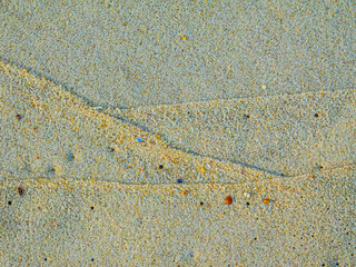 Wet sand with delicate lines created by ocean waves that resemble trend graphs. Illustration concept for business.