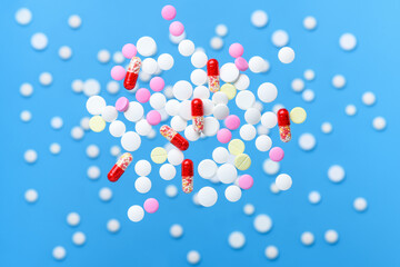 Flying pills and levitation tablets on blue background. Medicine and healthcare concept.