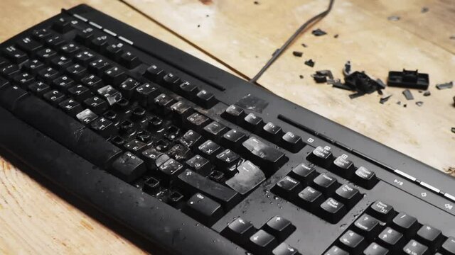 Hammer hitting computer keyboard. Damage keyboard. Broken office equipment. Old computer keyboard with smashed buttons. Garbage concept.