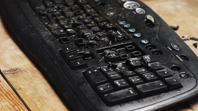 Hammer hitting computer keyboard. Damage keyboard. Broken office equipment. Old computer keyboard with smashed buttons. Garbage concept.