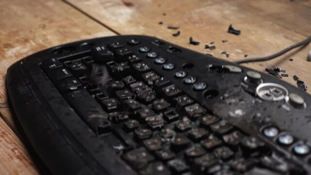 Hammer hitting computer keyboard. Damage keyboard. Broken office equipment. Old computer keyboard with smashed buttons. Garbage concept.