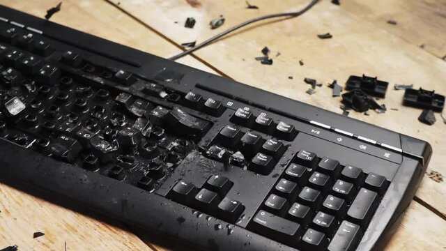 Hammer hitting computer keyboard. Damage keyboard. Broken office equipment. Old computer keyboard with smashed buttons. Garbage concept.