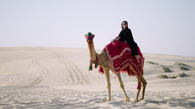 Tourist woman riding camel at the desert
