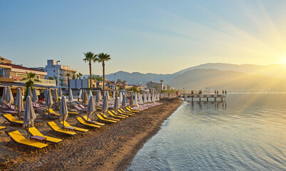 Deserted beach in the morning sun. The beach at dawn. Empty sunbeds. Beach without people. Marmaris