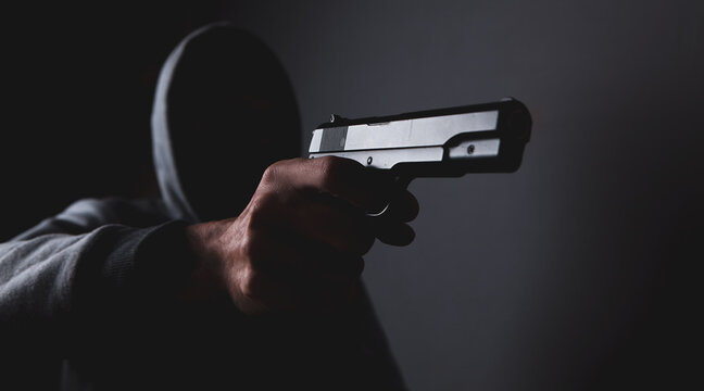 masked man holding a gun
