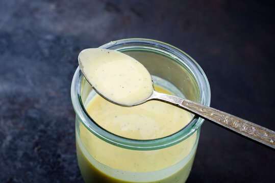Traditionelle bayrische Vanille Sauce f&uuml;r Apfelstrudel als close-up in einem Glass mit Textfreiraum 