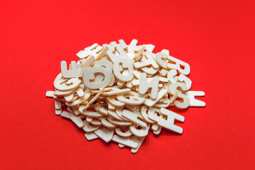 Heap of wooden latin alphabet letters number isolated on red background. Stack decorated quote words text. Creative greering card title