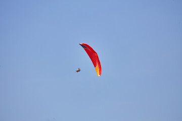 Paragliding in the sky. Paraglider flying in bright sunny day. Beautiful paraglider in flight on a turquise background.