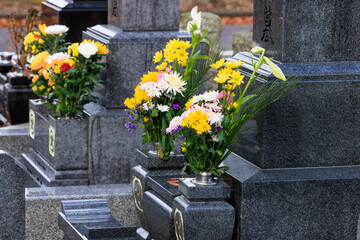 Fototapeta na wymiar 雨に濡れる墓と供花