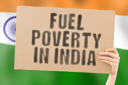 The phrase " Fuel poverty in India " on a banner in men's hand with blurred Indian flag on the background. Economic. Expensive. Depressed. Gasoline. Fossil. Problem. Supply. Social issues. Mumbai