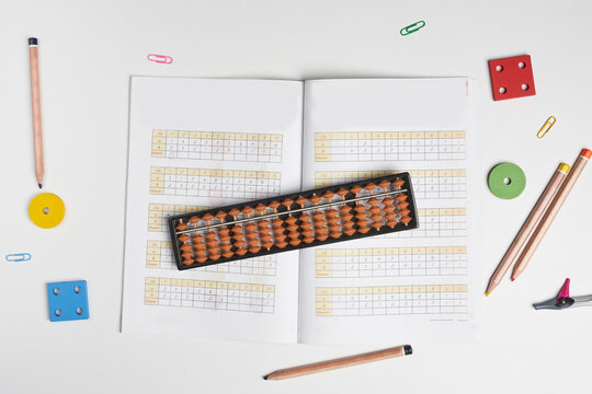 Creative lay out of mental mathematics items. Mental arithmetic for kids. School items for kids. Abacus with school supplies, drawing compass on colored background. Mental mathematics, math concept