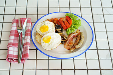 traditional breakfast on a plate on a table with a plaid tablecloth. 