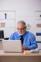 Old male employee working in the office