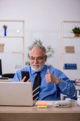 Old male employee working in the office