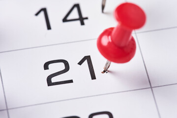 Colored push pins on monthly calendar page. Calendar appointments. Multicolored push pins on...
