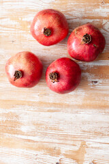 many pomegranates fruits arranged on light wooden background