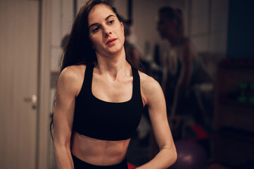Fototapeta na wymiar Portrait of a young woman in motion while training in the gym