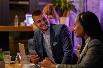 Two business people having a meeting in a cafe while using a laptop