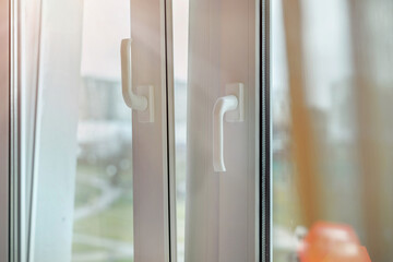 Open pvc window frame with white vertical handle close up