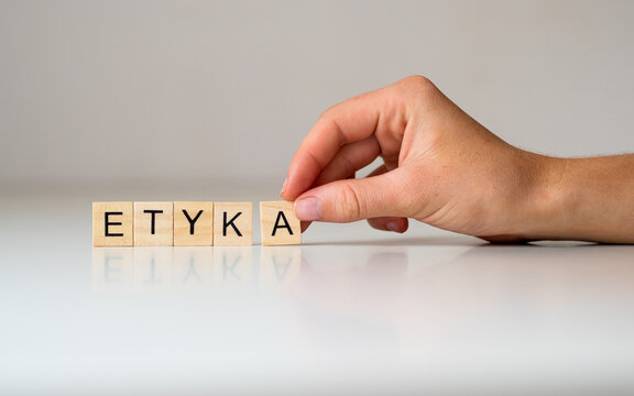 Etyka - napis z drewnianych kostek, dłoń