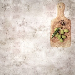 stylish textured old paper background with small branch of olive tree with fruit