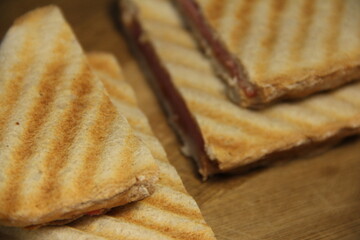Slices of grilled sandwiches on a wooden background. close up.