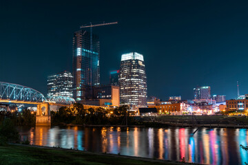 Panoramic view of Broadway district of Nashville over Cumberland River at illuminated night skyline, Tennessee, USA. This city is known as a center for the music industry, especially country music