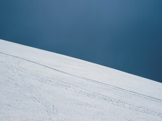 Ski slope. Snow mountain and dark blue sky. Beautiful minimalistic landscape of white snow hill.