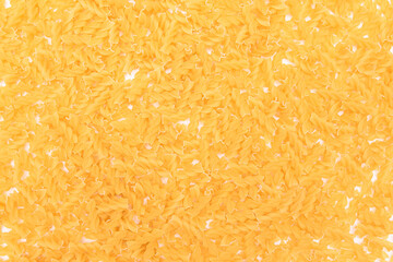 Uncooed Fusilli Pasta - Background. Texture of Bright Golden Dry Macaroni