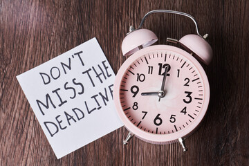 Dont miss the deadline. Deadline text on piece of paper, alarm clock and monthly calendar on the desk. White card with Deadline text and last date of month. Last day, Last chance concepts
