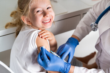 vaccination of children, a little girl at a doctor's appointment, an injection in the arm, the conce