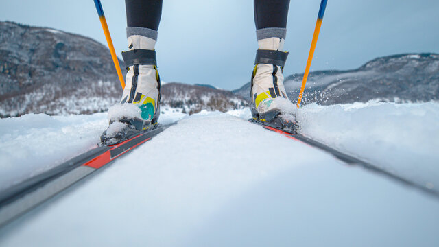 LOW ANGLE: Female athlete skis along tracks running around a training center.
