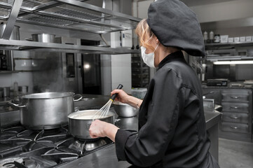 Portrait of confident female chef working in commercial kitchen. High quality photo