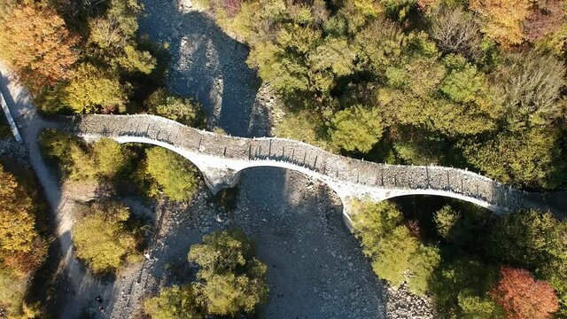 Aerial view of old Kalogeriko triple arched stone bridge on Vikos canyon, Zagorohoria, Greece, Europe