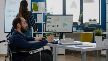 Corporate business people discussing in financial start up business office, african manager showing ideas to handicapped employee immobilized in wheelchair, explaning strategy, sharing problem,