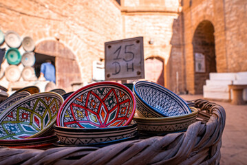 Colorful ceramics and bowl displayed outside in a factory shop or bazaar. Handmade and painted bowls from Morocco