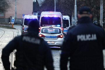 Polscy policjanci i ich pojazdy podczas wieczornej służby w mieście. 
