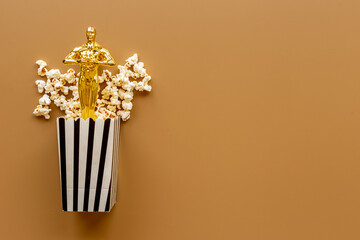 Cinema industry concept with film award statue in popcorn
