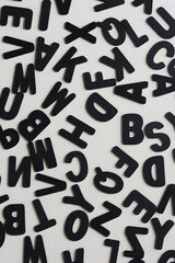 background with black chalk letters randomly scattered on paper