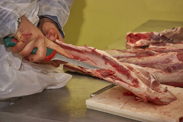 Butcher cleaning the meat from impurities