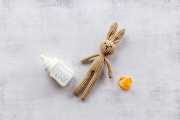 Child toy knitted rabbit with milk bottle, overhead view
