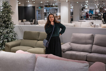 Woman choosing sofa in mall