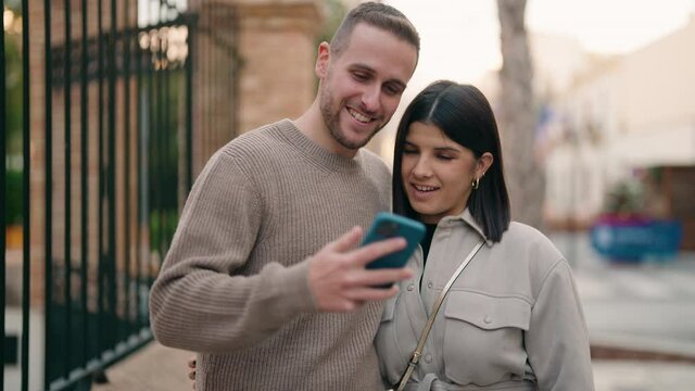 Young couple smiling confident make selfie by the smartphone at street
